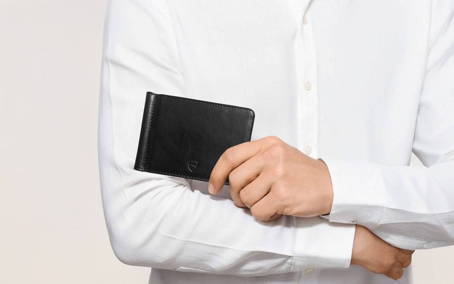 Vaultskin BROMPTON black leather wallet held by man in white shirt, slim minimalist wallet with RFID protection